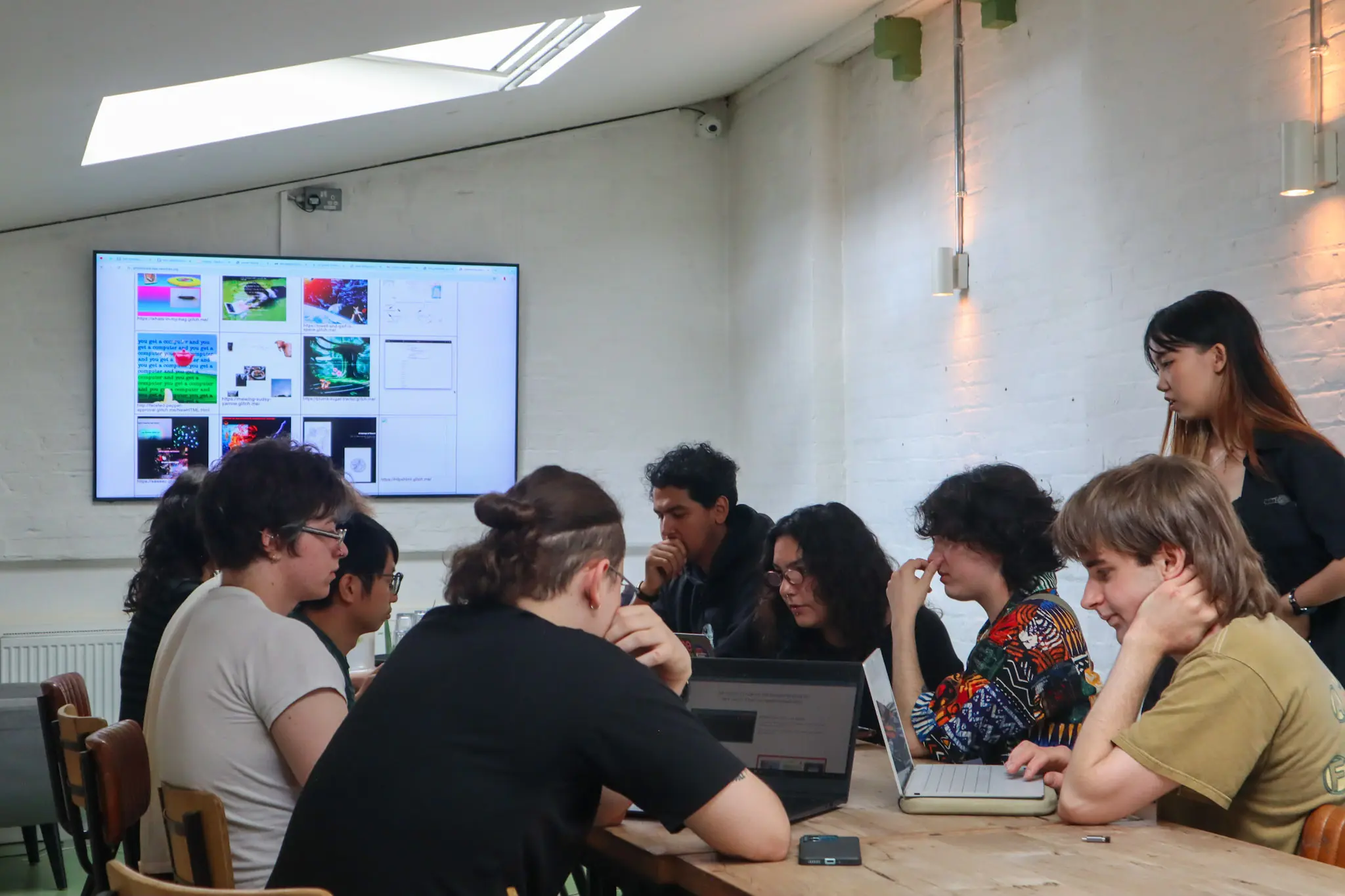 Group gathered around laptops during glitch workshop