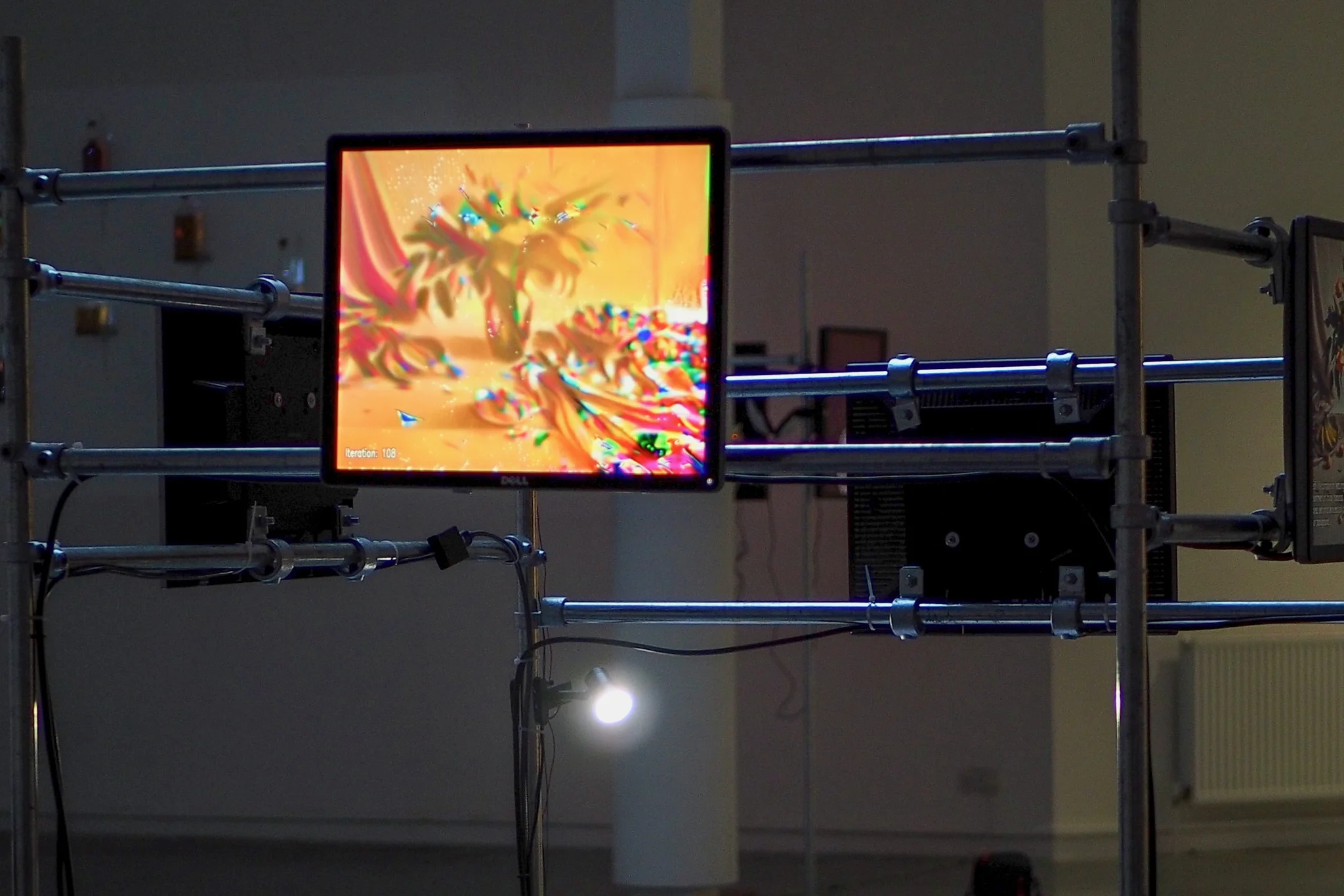 A screen held with metal bars, showing a still life scene of fruit in the centre